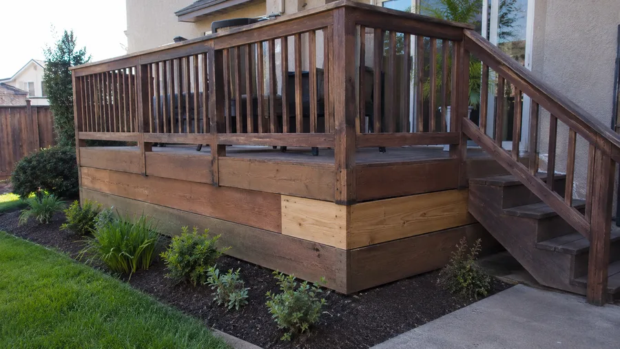 Deck with a replaced fascia section visible against the weathered original boards