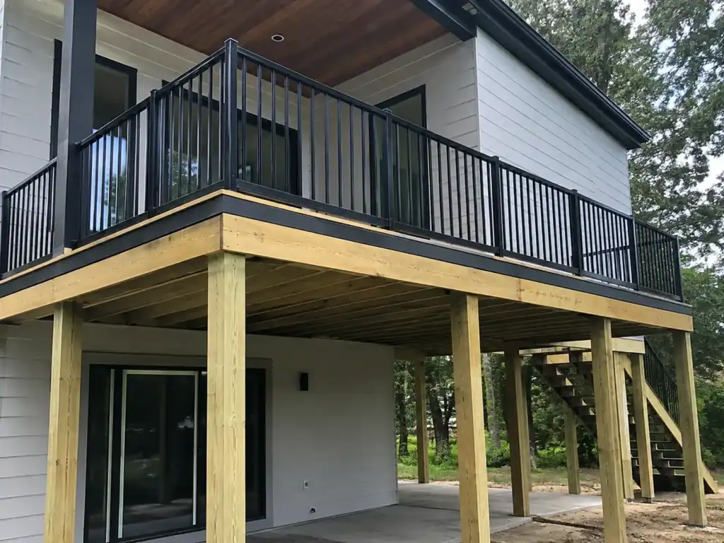 Elevated balcony raised well above grade on tall posts, with stairs descending to ground level