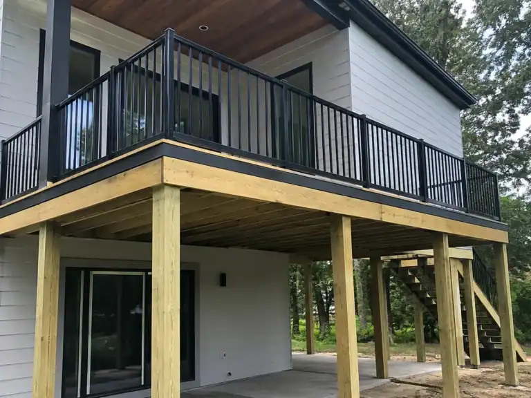 Elevated balcony raised well above grade on tall posts, with stairs descending to ground level