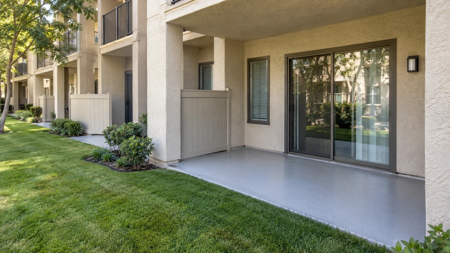 Fresh gray textured deck coating on a ground floor patio below upper floor balconies
