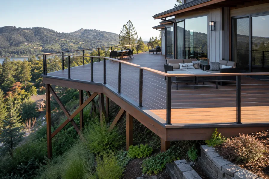 Cantilevered deck framing on timber posts of varying length with diagonal cross-bracing over a steep slope