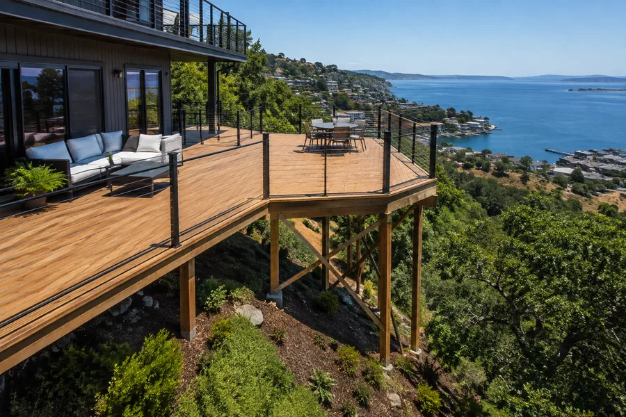 Octagonal deck extension cantilevered on angled timber posts and cross-bracing over a steep hillside