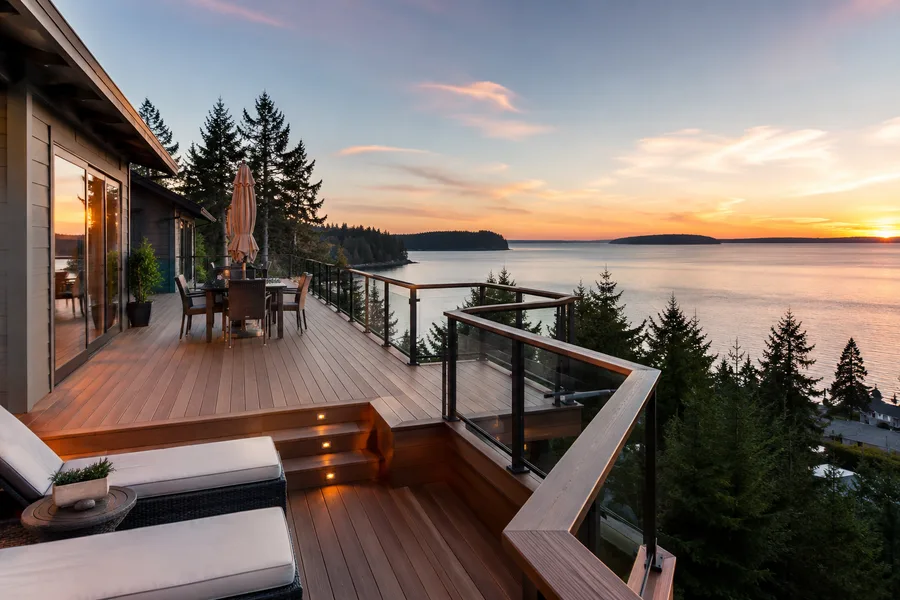 Hillside deck with built-in steps and lighting leading down to a lower level at dusk