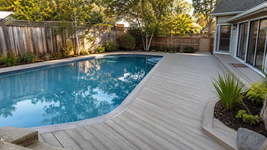 Composite decking wrapping an in-ground pool to the coping edge