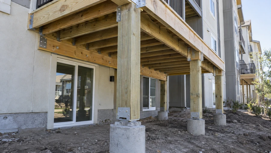 Elevated deck structure on posts with metal bases, beams and joists in place