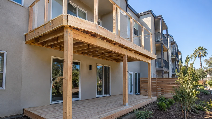 New deck and balcony framed together on the same elevation, boards laid at ground level
