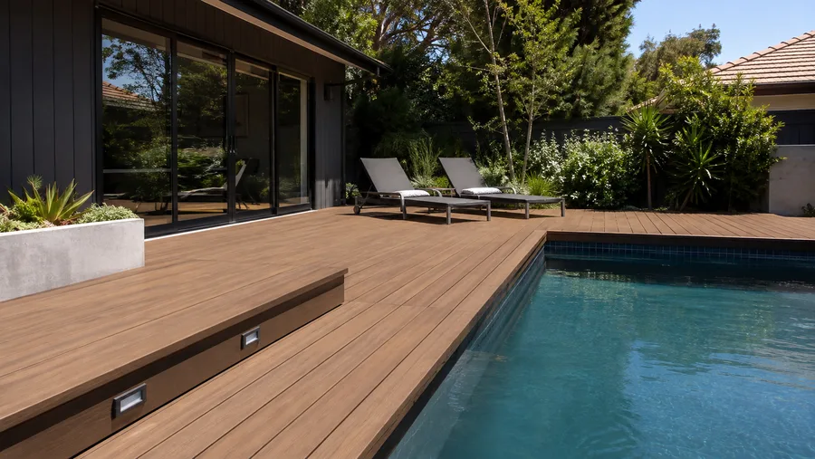 Composite pool deck with integrated step lighting running to the pool edge