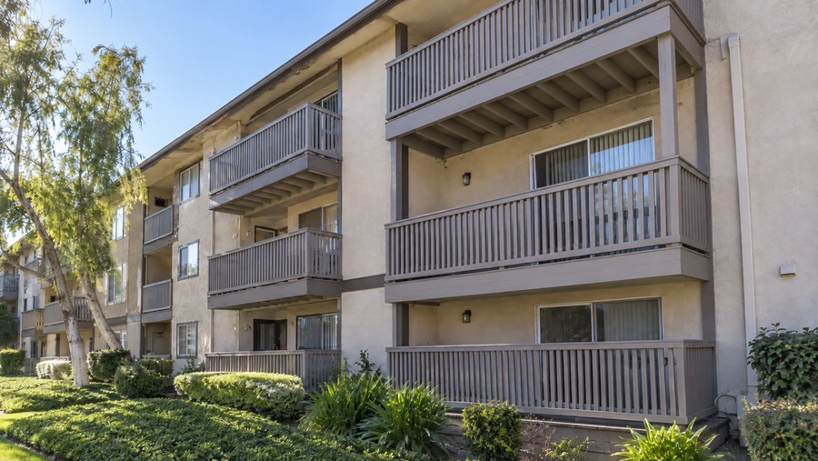 Completed apartment elevation after balcony replacement, with new guardrails throughout