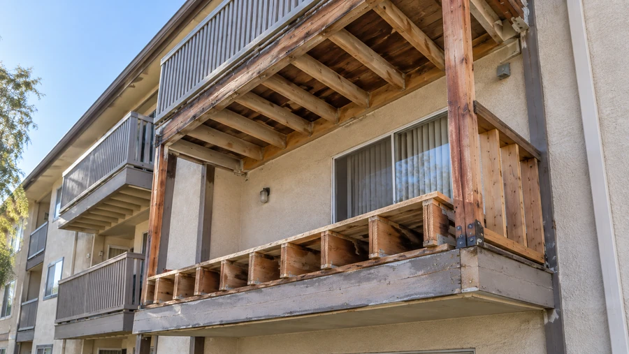 Close view of a balcony opened up, showing joist ends and the connection at the wall