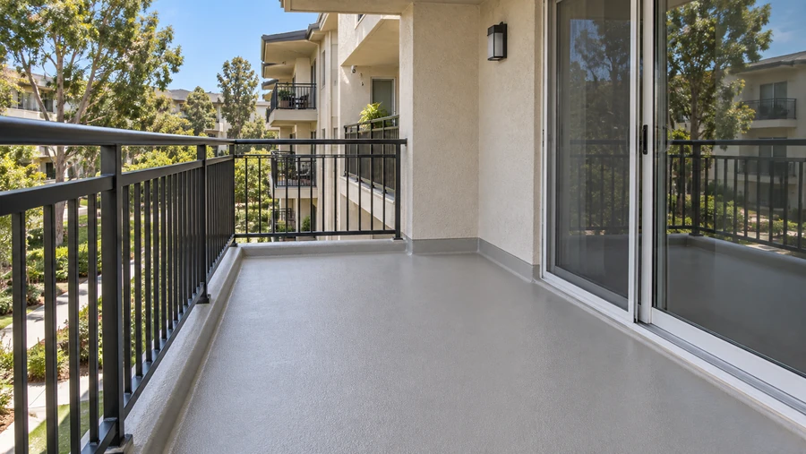 Balcony with a new textured waterproof coating turned up at the wall and over the edge