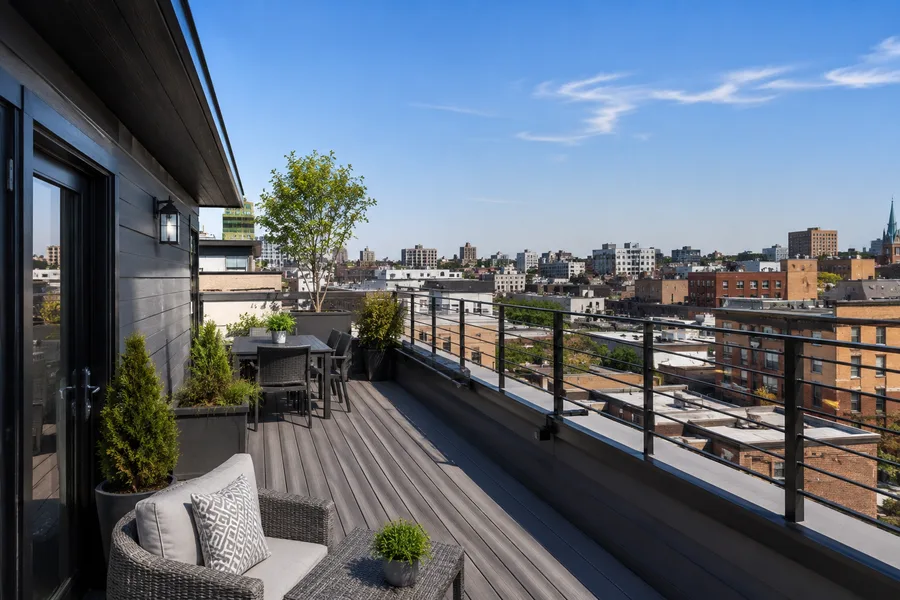 Rooftop balcony guardrail mounted to the parapet face on brackets, clear of the roof surface