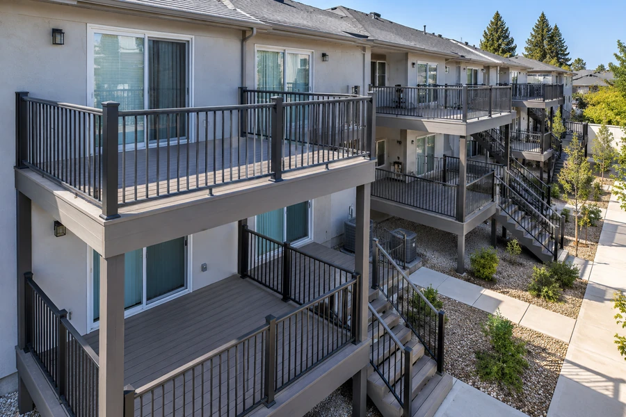 Completed composite decks and balconies across a multifamily elevation with aluminium guardrails