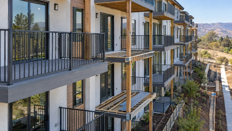Stacked balconies mid-installation, some boarded and some still open to the joists