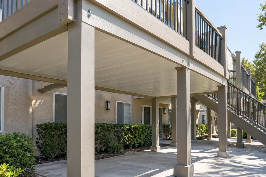 Under-deck ceiling above a ground-floor patio, joists fully enclosed and the area usable in rain