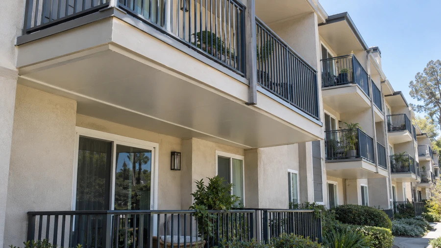 Balconies with under-deck ceilings above ground-floor units across a courtyard elevation