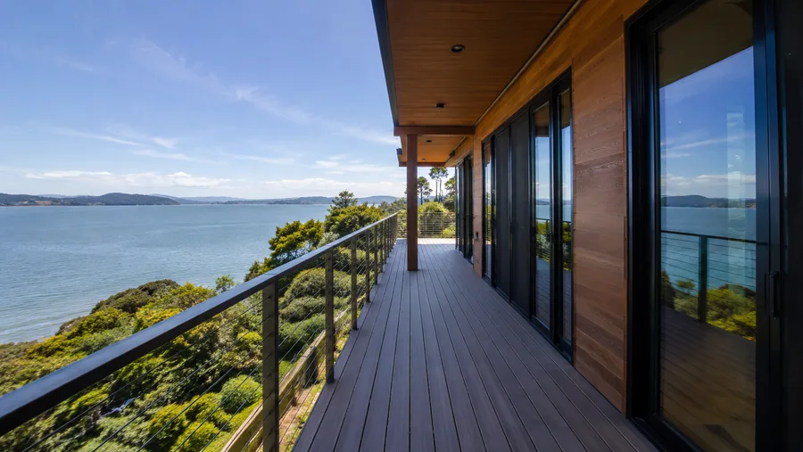Waterfront balcony with composite decking and cable guardrails facing open water